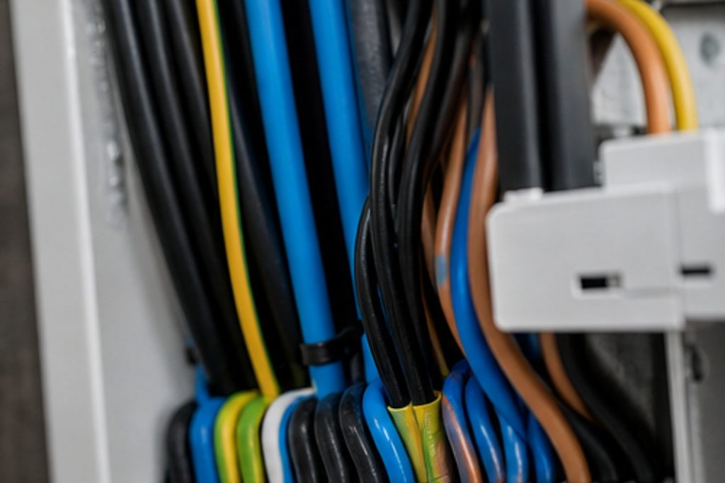 Tidy bundle of blue, black and green-yellow cables in a distribution board